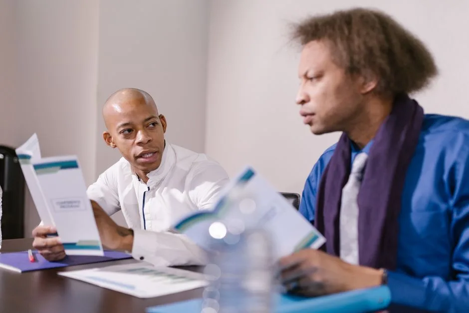 Two professionals engaged in a focused discussion during a business meeting